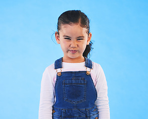 Image showing Tantrum, attitude and portrait of child on blue background with upset, mad and frustrated facial expression. Behaviour, pout and young girl with sad face for anger, tantrum and emotion in studio
