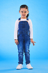 Image showing Angry, attitude and portrait of child on blue background with upset, mad and frustrated facial expression. Behaviour, youth and young girl with body language for anger, tantrum and emotion in studio