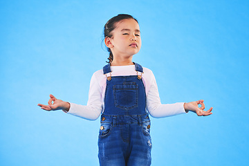 Image showing Girl child, zen and meditation in studio with eyes closed, peace and wellness by blue background. Female kid, mindfulness and balance chakra for health, breathing and development with yoga for energy