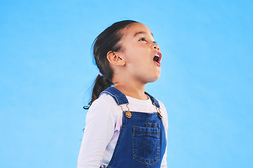 Image showing Shock, wow and girl child in a studio with mockup space for advertising, promotion or marketing. Youth, wtf and young kid model with omg and surprise face expression by blue background with mock up.