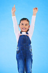 Image showing Success, girl child and champion, winner and achievement with happiness and excited isolated on blue background. Cheers, yes and winning with celebration, pride and happy kid with arms up in a studio