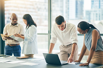 Image showing Meeting, business people with laptop and paperwork for workshop, motivation and collaboration. Teamwork, men and women at office desk together with computer, documents and brainstorming in training.