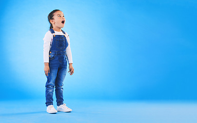 Image showing Shock, surprise and girl child in a studio with mockup space for advertising, promotion or marketing. Wow, wtf and full length of a kid model with omg face expression by blue background with mock up.