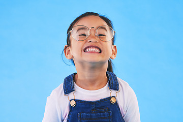 Image showing Glasses, student smile and Asian child in portrait in studio isolated on a blue background mockup space. Happy, nerd and face of school kid, girl or geek in casual clothes, fashion and style in Japan