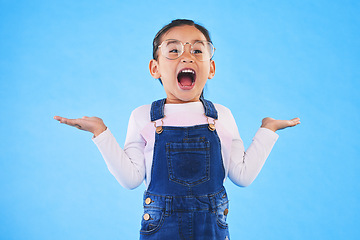 Image showing Excited, happy surprise and girl kid with hand gesture, expression and announcement isolated on blue background. Wow, reaction and happiness, news and opportunity with drama and open mouth in studio