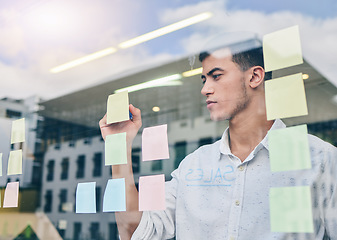 Image showing Glass, window and man, brainstorming and writing on sticky note, project management and strategy in workplace. Ideas, planning and business with moodboard, calendar and goals with productivity