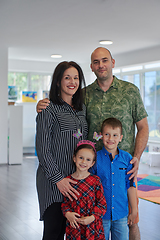 Image showing Portrait of a happy family. Photo of parents with children in a modern preschool classroom. Selective focus