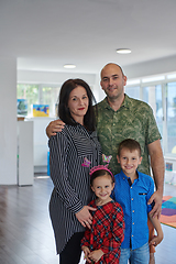 Image showing Portrait of a happy family. Photo of parents with children in a modern preschool classroom. Selective focus