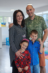 Image showing Portrait of a happy family. Photo of parents with children in a modern preschool classroom. Selective focus