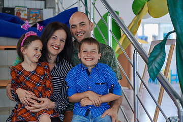 Image showing Portrait of a happy family. Photo of parents with children in a modern preschool classroom. Selective focus