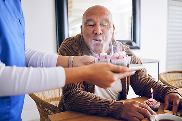 Image showing Celebration, blowing candles and a man with a caregiver, cupcake and birthday in a nursing home. Happy, house and a senior person or patient with cake or food from a healthcare employee for a party