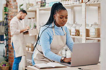 Image showing Grocery store, small business and black woman at counter with laptop for stock inventory, planning and sales report. Computer, internet and manager at sustainable supermarket with eco friendly care.