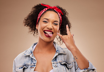 Image showing Woman, horns sign and studio portrait with tongue, comic smile and funny face with beauty by brown background. African girl, model or student with icon, crazy and rock star hand with laugh for beauty