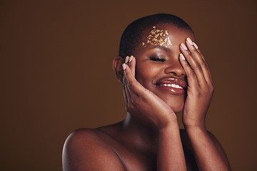 Image showing Art, beauty and black woman with gold makeup on brown background, glitter paint and cosmetics mockup. Shine, glow and African model in studio space for fashion, aesthetic freedom and luxury skincare.