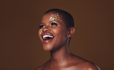 Image showing Gold, makeup and woman laughing with beauty and luxury treatment and creative spa mask. Glitter, art dermatology and African female person happy from skincare and golden cosmetics in studio