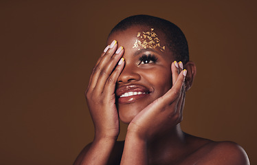 Image showing Art, smile and black woman with gold makeup on brown background, glitter and cosmetics mockup. Beauty shine, glow and African model in studio space for fashion, aesthetic freedom and luxury skincare.