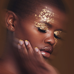 Image showing Gold beauty, blur and black woman with hand on face closeup with makeup and cosmetics in studio. Brown background, African female model and manicure with golden shine and glow from paint sparkle