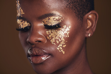 Image showing Gold, creative and black woman with makeup for beauty aesthetics isolated in a studio brown background eyes closed. Art, luxury and face of African person with cosmetic glamour or design for skincare