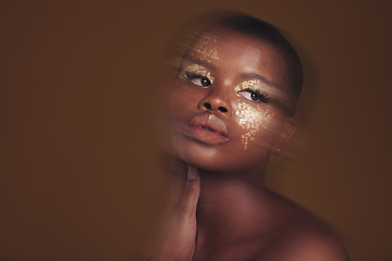 Image showing Gold beauty, blurred and black woman makeup with mockup space and cosmetics in studio. Brown background, African female model and glitter with golden shine and skin glow from facial paint sparkle