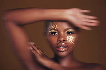 Image showing Art, portrait of black woman with gold makeup and blurred background, glitter paint and cosmetics. Shine, glow and African model in studio for beauty, fashion and aesthetic freedom in luxury skincare