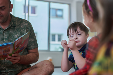 Image showing Reading time in an elementary school or kindergarten, a teacher reading a book to children in an elementary school or kindergarten. The concept of pre-school education. Selective focus