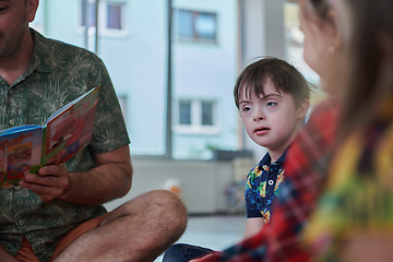 Image showing Reading time in an elementary school or kindergarten, a teacher reading a book to children in an elementary school or kindergarten. The concept of pre-school education. Selective focus