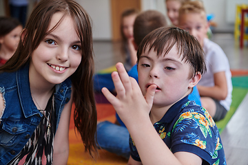 Image showing A girl and a boy with Down's syndrome in each other's arms spend time together in a preschool institution