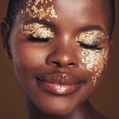 Image showing Gold, creative and black woman with makeup for beauty aesthetics isolated in a studio brown background eyes closed. Art, luxury and face of African person with cosmetic glamour or design for skincare