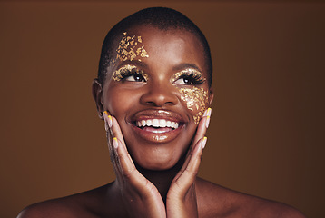 Image showing Gold, glitter face and black woman beauty with makeup and smile in studio with sparkle cosmetics. Brown background and female model with golden paint for skin glow art and creative facial shine