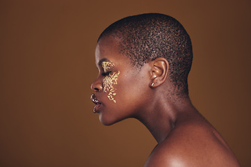 Image showing Art, profile of black woman with gold makeup and blurred background, glitter paint and cosmetics. Shine, glow and African model in studio for beauty, fashion and aesthetic freedom in luxury skincare.