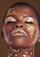 Image showing Gold, art and face of black woman with makeup for beauty aesthetics isolated in a studio brown background eyes closed. Creative, luxury and African person with cosmetic glamour or design for skincare