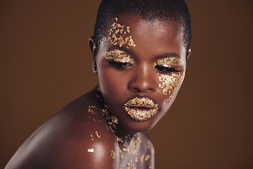 Image showing Art, studio and black woman with gold makeup on brown background, glitter paint facial and cosmetics. Shine, glow and face of African model for beauty, fashion or aesthetic freedom in luxury skincare