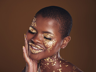 Image showing Black woman, relax and gold makeup with luxury dermatology and skincare mask with glitter. Sparkle, smile and beauty with happy glow and shine of cosmetics and model in a studio with facial art