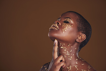 Image showing Profile, beauty and black woman with gold makeup, mockup and brown background with art, glitter paint and cosmetics. Shine, glow and African model in studio space for aesthetic, luxury and skincare.