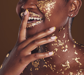 Image showing Gold, smile and woman mouth closeup with makeup and luxury treatment with rich spa mask. Glitter, golden dermatology and African person happy from creative skincare and art cosmetics in studio