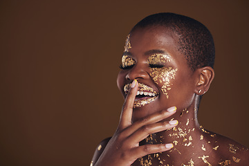 Image showing Happy laugh of black woman with gold makeup, mockup on brown background and glitter paint for cosmetics. Shine, glow and smile, African model in studio for facial beauty and funny aesthetic luxury.