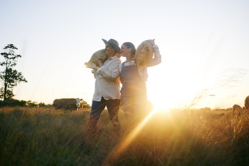 Image showing Farm harvest, women walking and countryside with a smile from working on a grass field with grain bag. Sustainability, eco friendly and agriculture outdoor at sunset in nature with farmer management