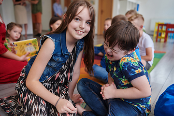 Image showing A girl and a boy with Down's syndrome in each other's arms spend time together in a preschool institution