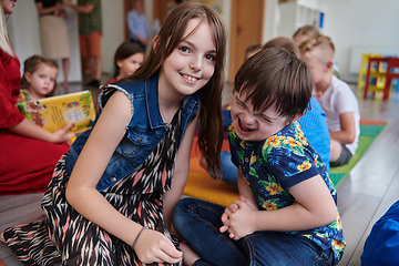 Image showing A girl and a boy with Down's syndrome in each other's arms spend time together in a preschool institution