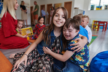 Image showing A girl and a boy with Down's syndrome in each other's arms spend time together in a preschool institution