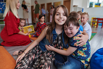 Image showing A girl and a boy with Down's syndrome in each other's arms spend time together in a preschool institution