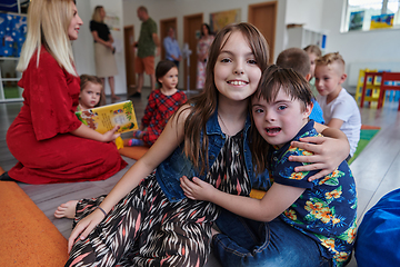 Image showing A girl and a boy with Down's syndrome in each other's arms spend time together in a preschool institution