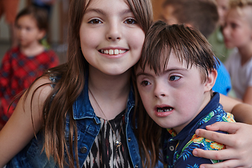 Image showing A girl and a boy with Down's syndrome in each other's arms spend time together in a preschool institution