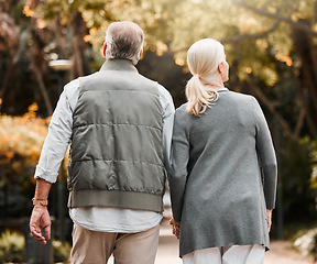 Image showing Holding hands, love and back with old couple in nature for bonding, happy and support. Relax, happiness and retirement with senior man and woman walking in countryside for vacation and commitment