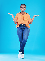 Image showing Portrait, showing and black woman with promotion, smile or opportunity on a blue studio background. Person, girl or model with happiness, decision or choice with presentation, discount deal or option