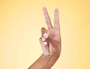 Image showing Closeup, hands and peace sign with emoji, support and voice on a yellow studio background. Hand of female, person and model showing v symbol, icon or shape for hope, trust in vote and mockup space