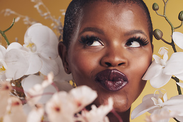 Image showing Makeup, beauty and face of black woman with flowers for wellness, skincare and facial in studio. Spa, aesthetic and African person with orchids for natural cosmetics and glamour on yellow background