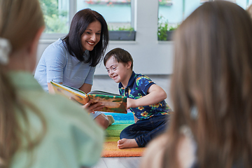 Image showing Reading time in an elementary school or kindergarten, a teacher reading a book to children in an elementary school or kindergarten. The concept of pre-school education. Selective focus