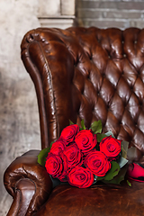 Image showing Bouquet Of Red Roses On An Old Leather Armchair