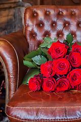 Image showing Bouquet Of Red Roses On An Old Leather Armchair
